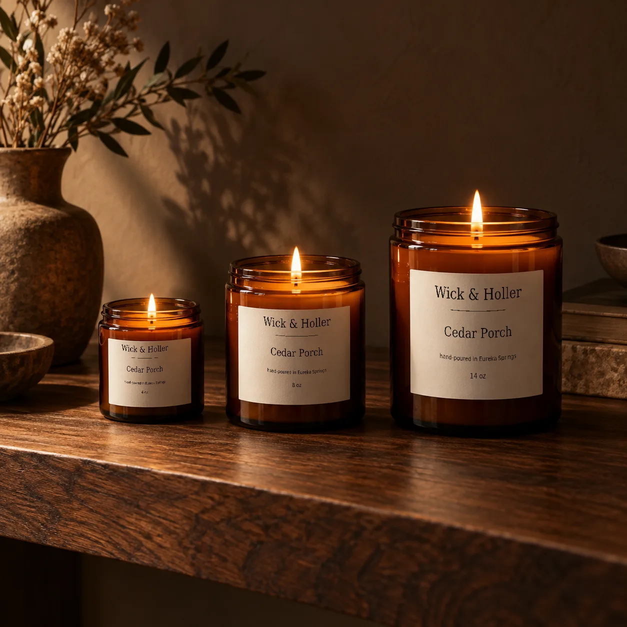 Three sizes of amber candle on walnut
