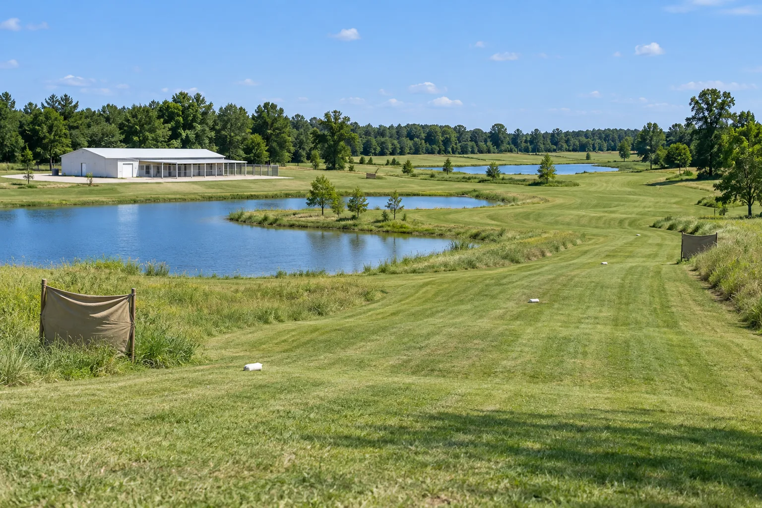 Mowed training lanes with a khaki holding blind beside the ponds